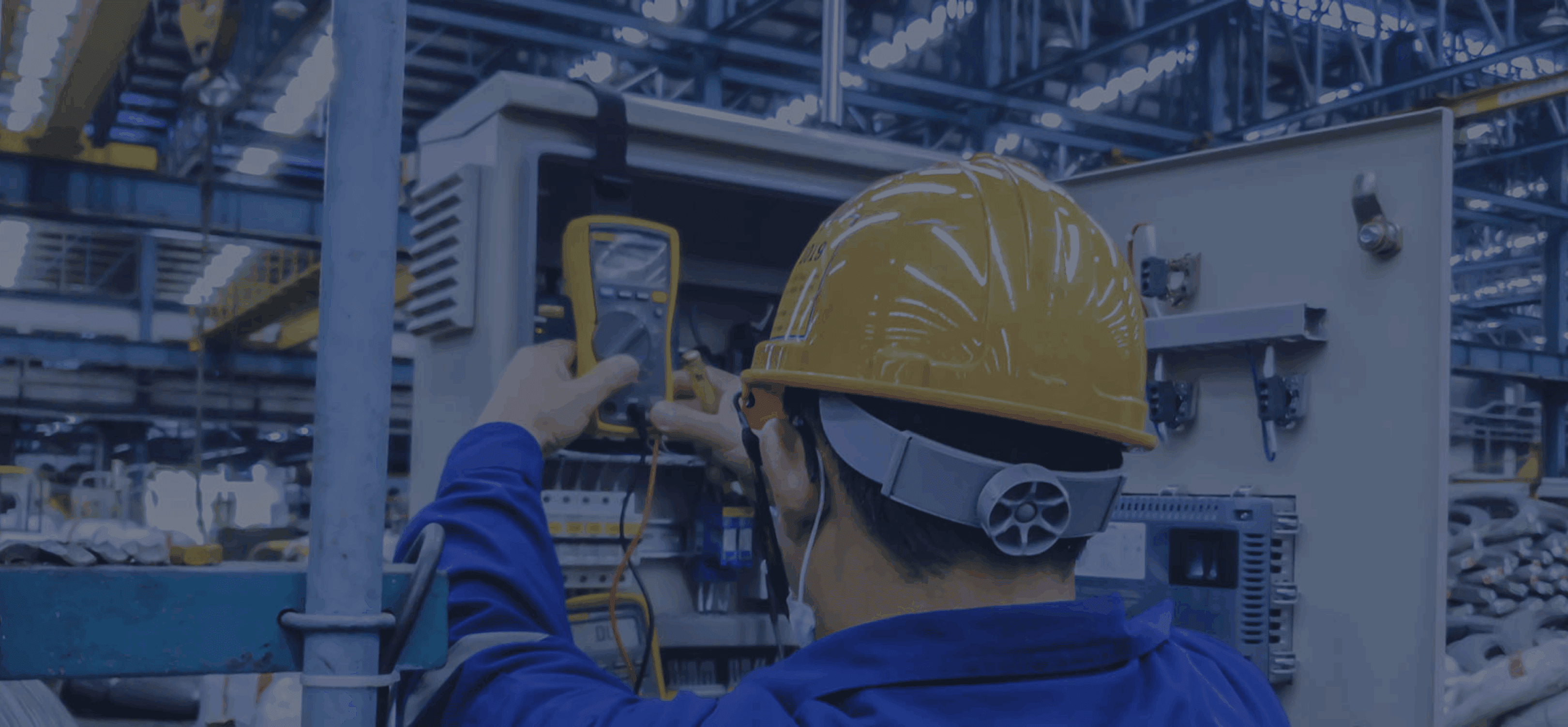 Worker checking electrical panel with multimeter.